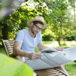 Mid adult man reading newspaper in garden